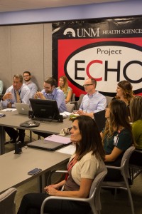 Surrounding Bouchonville at the Endo ECHO "hub" in Albuquerque are (l to r, at table): UNM endocrinologist Mark Burge, MD; UNM psychiatrist Brant Hagar, MD; nurse manager, Jessica Kirk; clinic coordinator Leena Matib; Endo ECHO CHW trainer, Vanessa Acosta; Project ECHO's Melissa Meier (seated in back are pharmacy students).